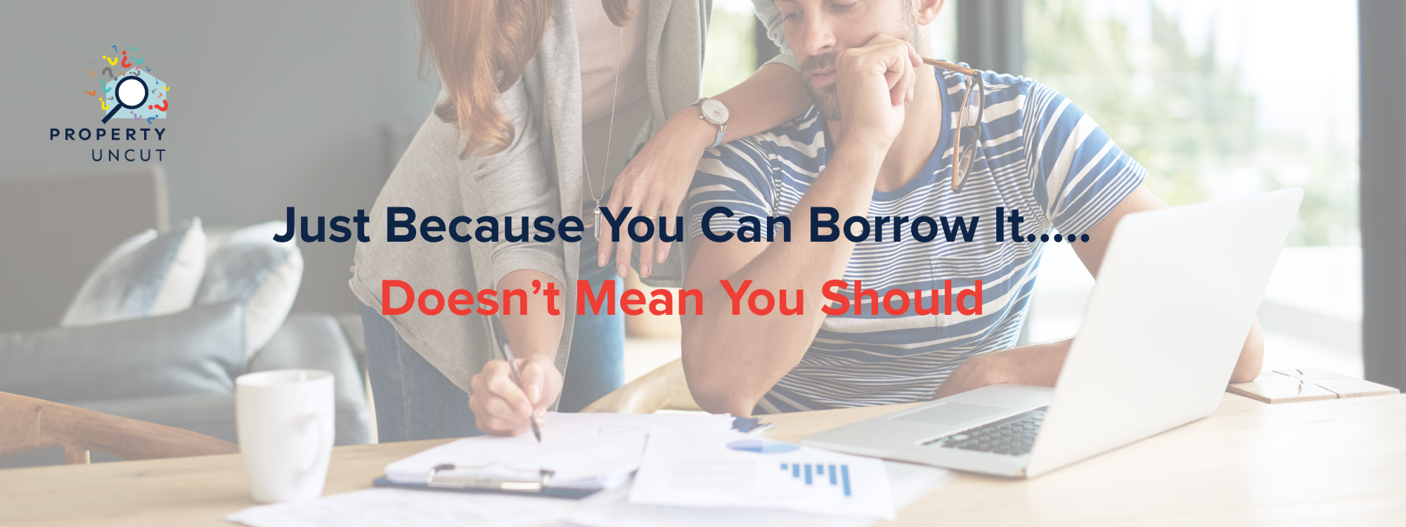 Couple reviewing loan documents, looking uncertain while calculating borrowing options for a property.